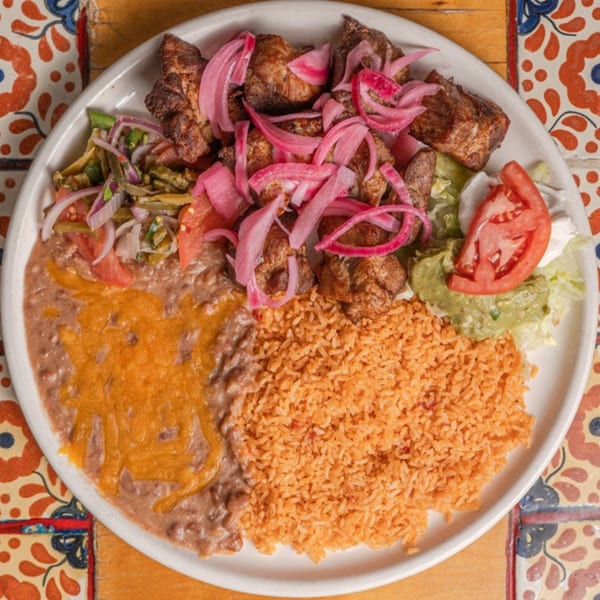 Don Pedro Mexican Restaurant's carnitas plate with rice, beans, guacamole, and pickled red onions.