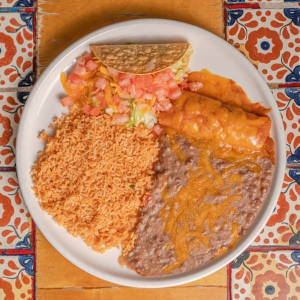 A Mexican combo plate with rice, refried beans, a cheese enchilada, and a crispy taco.